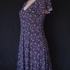 Casual floral dress with a V-neck and short sleeves, featuring pink and purple hues.