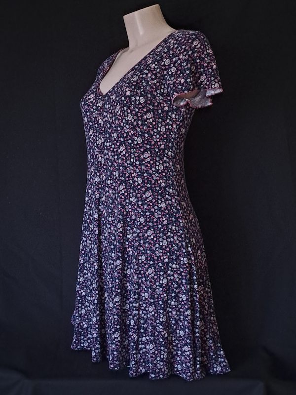 Casual floral dress with a V-neck and short sleeves, featuring pink and purple hues.