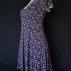 Casual floral dress with a V-neck and short sleeves, featuring pink and purple hues. Showcasing the back and silhouette.