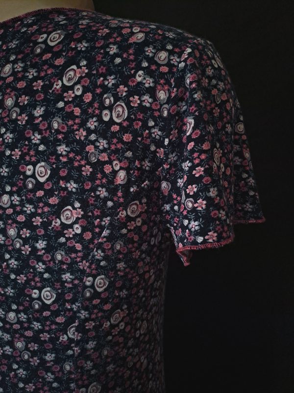 Casual floral dress with a V-neck and short sleeves, featuring pink and purple hues. Sleeve close-up showcasing floral rosy pattern.