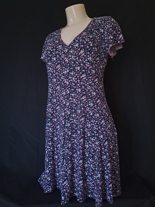 Casual floral dress with a V-neck and short sleeves, featuring pink and purple hues.