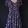 Casual floral dress with a V-neck and short sleeves, featuring pink and purple hues.