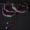Jewelry set consisting of three braided bracelets (purple suede cords with green floral beads), and a pair of handmade earrings featuring round purple pearls, small green glass beads and silver swirls.