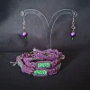 Jewelry set consisting of three braided bracelets (purple suede cords with green floral beads), and a pair of handmade earrings featuring round purple pearls, small green glass beads and silver swirls.
