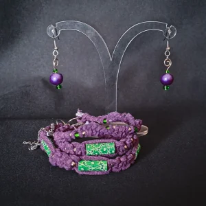 Jewelry set consisting of three braided bracelets (purple suede cords with green floral beads), and a pair of handmade earrings featuring round purple pearls, small green glass beads and silver swirls.
