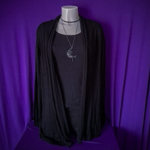 A black cardigan adorned with a necklace, emphasizing a blend of comfort and style in a refined outfit presentation.