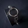 Black leather wristband with stainless steel spikes in assymetrical placement. Intertwined rings forming a chain and connecting th center large steel o-ring. A unique twist to a classis alternative fashion accessory of gothic or punk styles.