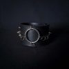 Black leather wristband with stainless steel spikes in assymetrical placement. Intertwined rings forming a chain and connecting th center large steel o-ring. A unique twist to a classis alternative fashion accessory of gothic or punk styles.