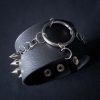Black leather wristband with stainless steel spikes in assymetrical placement. Intertwined rings forming a chain and connecting th center large steel o-ring. A unique twist to a classis alternative fashion accessory of gothic or punk styles.