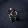 Black leather wristband with stainless steel spikes in assymetrical placement. Intertwined rings forming a chain and connecting th center large steel o-ring. A unique twist to a classis alternative fashion accessory of gothic or punk styles.