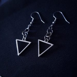 A pair of dangle earrings featuring silver triangle frames and three small round rings connecting them to silver hooks.